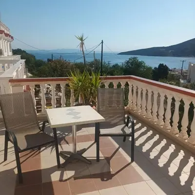 a table and chairs on a balcony with the ocean at Seva' s Studios in Livadia