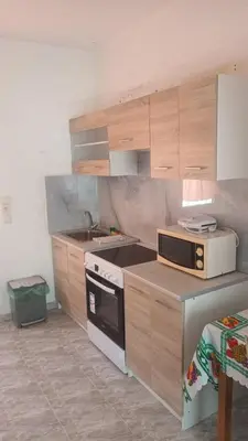 a kitchen with wooden cabinets and a stove top oven at Seva' s Studios in Livadia