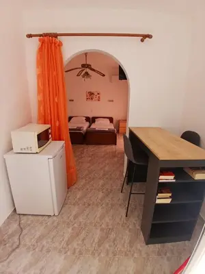 a room with a desk and a bedroom with a bed at Seva' s Studios in Livadia