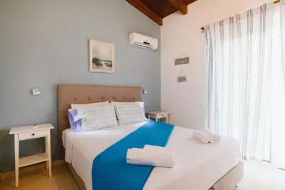a bedroom with a bed with towels on it at Cathrin Beachfront Villa in Plimmiri