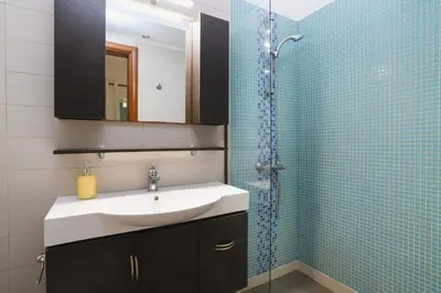 a bathroom with a sink and a shower with a mirror at Cathrin Beachfront Villa in Plimmiri