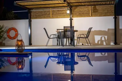 a table and chairs sitting next to a swimming pool at MonaLisa Villa in Pefki Rhodes