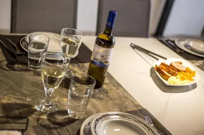 a bottle of wine sitting on a table with glasses at MonaLisa Villa in Pefki Rhodes