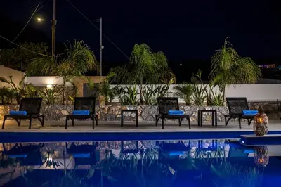 a group of chairs by a pool at night at MonaLisa Villa in Pefki Rhodes