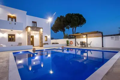 a villa with a swimming pool at night at MonaLisa Villa in Pefki Rhodes