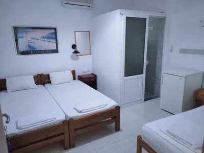 a bedroom with two twin beds and a shower at Cleopatra's House Apartments in Archangelos