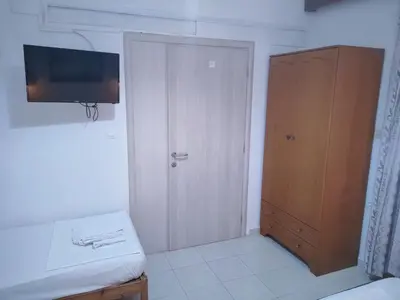 a room with a closet and a door with a television at Cleopatra's House Apartments in Archangelos