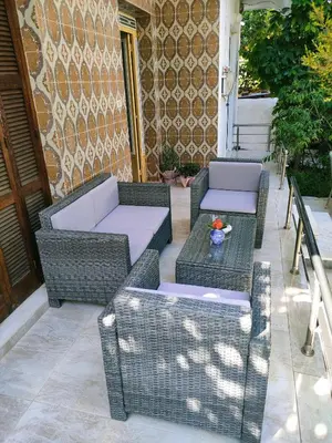 two wicker chairs and tables on a patio at Cleopatra's House Apartments in Archangelos