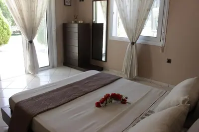a bedroom with a bed with flowers on it at Heliopetra Villa in Koskinou