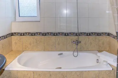a bath tub with a faucet in a bathroom at Heliopetra Villa in Koskinou