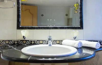 a sink in a bathroom with a mirror and towels at Heliopetra Villa in Koskinou