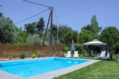 a swimming pool in the backyard of a house at Heliopetra Villa in Koskinou