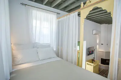 a bedroom with a white bed and a window at Marouli Traditional Villa in Koskinou