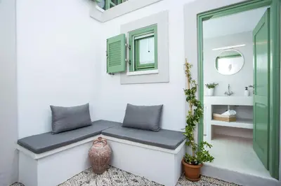 a bench in a room with a mirror and a vase at Marouli Traditional Villa in Koskinou