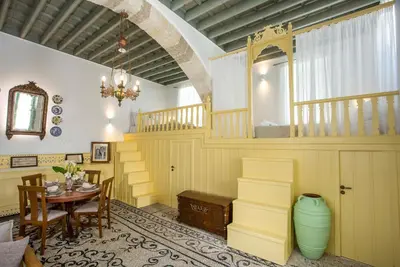 a dining room with a table and a staircase at Marouli Traditional Villa in Koskinou