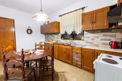 a kitchen with wooden cabinets and a table in it at Alonia Summerhouse in Fanes in Phanaes