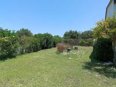 a backyard with a yard with grass and bushes at Alonia Summerhouse in Fanes in Phanaes