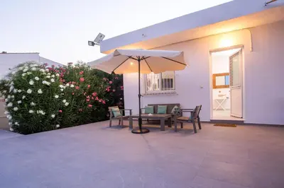 a patio with a table and an umbrella at Celini beach house in Kiotari