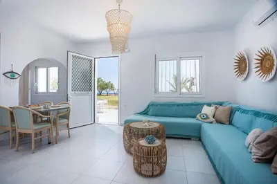 a living room with a blue couch and a table at Celini beach house in Kiotari