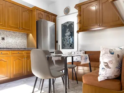a kitchen with a table and chairs and a refrigerator at NJ Apartments: The Island Edition in Rhodes Town