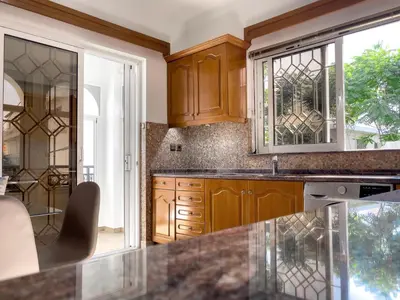 a kitchen with wooden cabinets and a counter top at NJ Apartments: The Island Edition in Rhodes Town