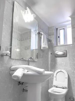 a bathroom with a sink and a toilet and a mirror at NJ Apartments: The Island Edition in Rhodes Town