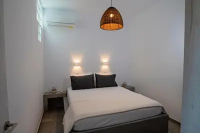 a small bedroom with a bed and a pendant light at Aethrèa Apartments in Haraki