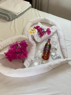 a tray with flowers and wine glasses on a bed at Lindos Athena in Líndos