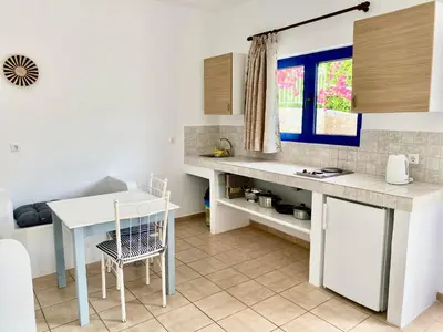 a kitchen with a counter and a table and a window at Lindos Athena in Líndos