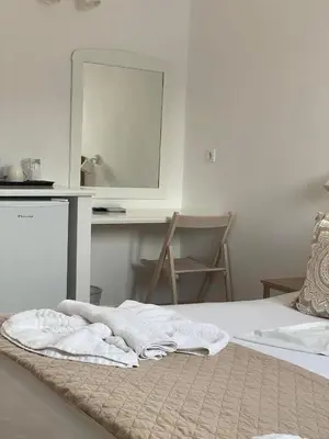 a bedroom with a bed with a mirror and a desk at Lindos Athena in Líndos