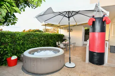 a hot tub with an umbrella and an inflatable punching bag at Angels Villa in Kremasti