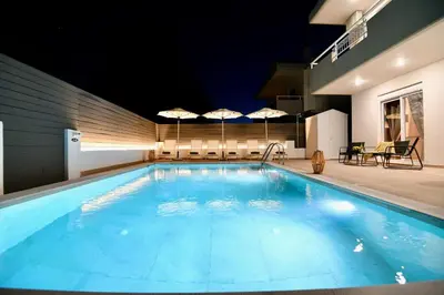 a large swimming pool with umbrellas in a building at Angels Villa in Kremasti