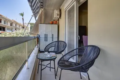 a balcony with three chairs and a glass table at Academia in Rhodes Town