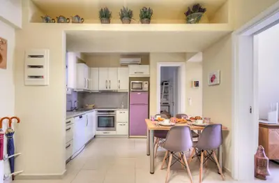 a kitchen with a wooden table and purple appliances at Academia in Rhodes Town