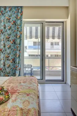 a bedroom with a bed and a large window at Academia in Rhodes Town