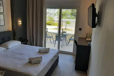 a bedroom with a bed and a balcony with a table at Luxury 1 bedroom apartment in Ialysos in Ialyssos