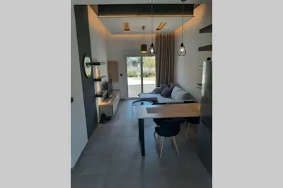 a living room with a couch and a table at Luxury 1 bedroom apartment in Ialysos in Ialyssos
