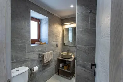 a bathroom with a sink and a toilet and a mirror at Althea Apartments 2 in Halki
