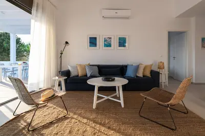 a living room with a couch and a table and chairs at VILLA IRIS in PEFKOS, PINE VILLAS in Pefki Rhodes
