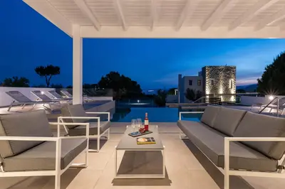 a patio with chairs and a table and a pool at VILLA IRIS in PEFKOS, PINE VILLAS in Pefki Rhodes