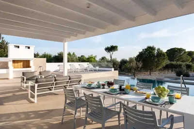 a patio with a table and chairs and a pool at VILLA IRIS in PEFKOS, PINE VILLAS in Pefki Rhodes