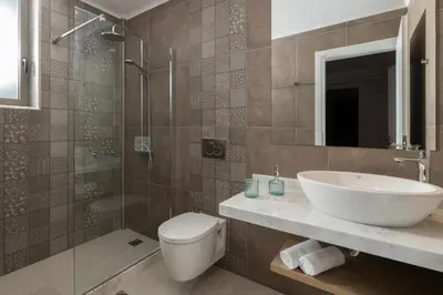 a bathroom with a sink and a toilet and a shower at VILLA IRIS in PEFKOS, PINE VILLAS in Pefki Rhodes