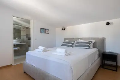 a white bedroom with a large bed with towels on it at VILLA IRIS in PEFKOS, PINE VILLAS in Pefki Rhodes
