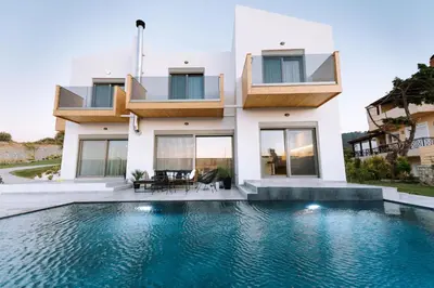 a house with a swimming pool in front of it at Brillante Villa in Ialyssos