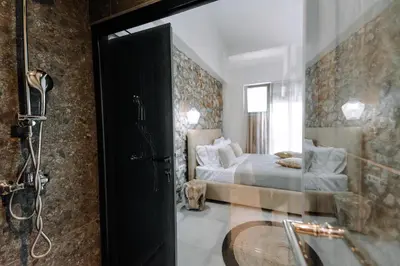 a bathroom with a shower and a bed and a tub at Brillante Villa in Ialyssos