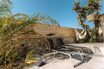 a hammock and a bench on a patio at Brillante Villa in Ialyssos
