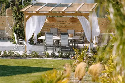 a wooden gazebo with a table and chairs at Brillante Villa in Ialyssos