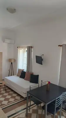 a living room with a white couch and a table at San Marco Guesthouse in Kattavía