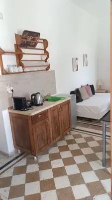a living room with a table and a bed at San Marco Guesthouse in Kattavía