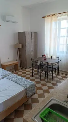 a room with a table and chairs in a room at San Marco Guesthouse in Kattavía